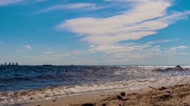 Güzel kumlu bir sahil, dalgalar ve kumsalda mavi gökyüzü. Zaman aşımı.