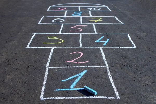 Hopscotch game drawn with chalk on the asphalt