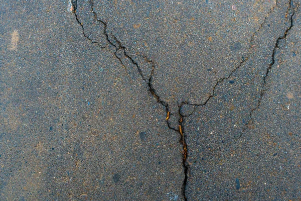 crack in the asphalt background. Damaged road surface