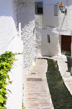 Dar asfalt bir dağ deresi için çökmüş, beyaz evler fenerlerle süslenmiş, Capileira, Endülüs, İspanya