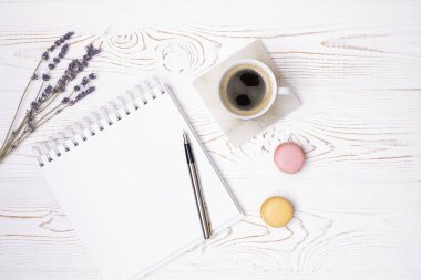 Boş günlükten, bir fincan kahveden, badem kurabiyesinden ve lavanta çiçeklerinden oluşan bir kompozisyon. Moda düzlüğü