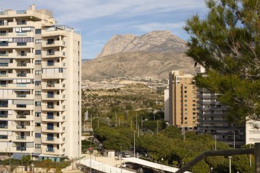Natural park and residential complex on the background of Mount Puig Campana in La Cala de Fenistrat, Benidorm, Spain. clipart