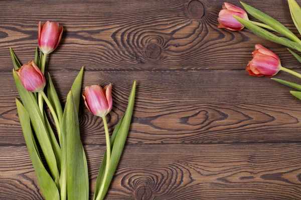 Kırsal bir masadaki kırmızı lale çiçekleri çerçevesi 8 Mart 'ta, Uluslararası Kadınlar Günü' nde, doğum gününde ya da mesajlaşmak için kullanılan anneler gününde.