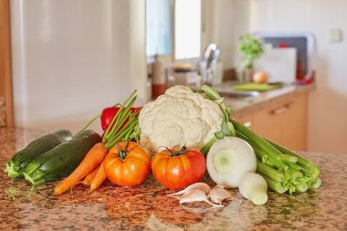 İtalyan sebze çorbası için malzemeler. Kereviz, domates, soğan ve havuç, karnabahar ve sarımsak, mutfaktaki masada kabak.