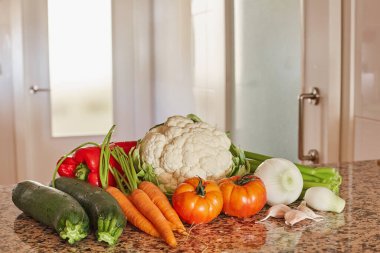 İtalyan sebze çorbası için malzemeler. Kereviz, domates, soğan ve havuç, karnabahar ve sarımsak, mutfaktaki masada kabak..