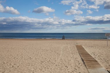 Bir cankurtaran ve Costa Blanca İspanya 'sında denize giden bir tahta yolu olan ıssız kumlu bir sahil.
