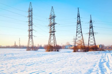 karlı bir alanda elektrik yüksek gerilim direkleri