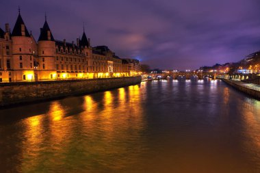 Paris 'teki Conciergerie ve Seine nehrinin gece manzarası 