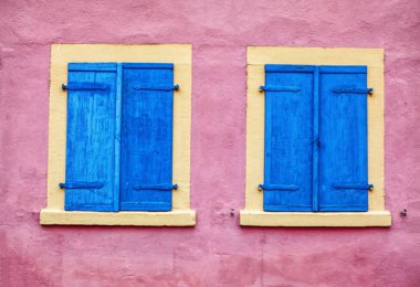 Ahşap mavi pencereli pembe duvar