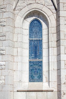 Beyaz duvardaki dar kilise penceresi