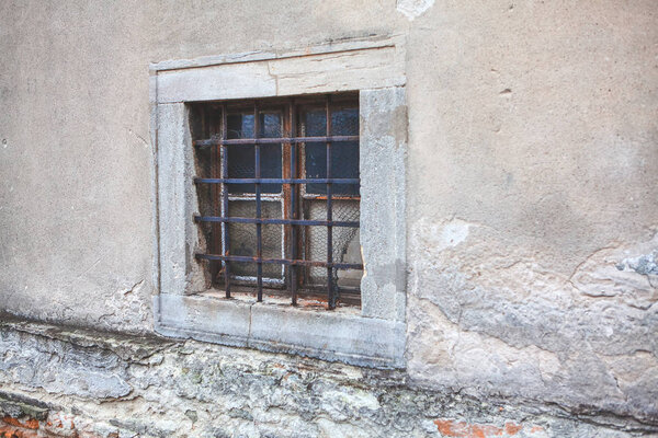 Old window with grates of ancient building