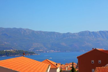 Deniz kenarında kırmızı çatıları olan evler ve oteller