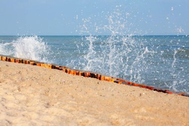 Dalgalar kumlu deniz kıyısına vuruyor.