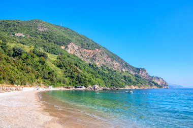 Güzel bir göl ve çakıl taşı plajı olan muhteşem bir manzara. 