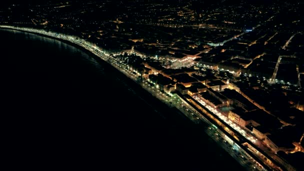 Vista aérea nocturna de la ciudad iluminada de Niza en Francia. Vuelo sobre el paseo marítimo . — Vídeos de Stock