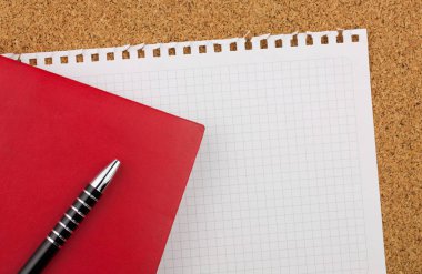 Boş kare beyaz kağıt sayfası metni Not Defteri'nden wrested. Kırmızı defter, siyah kalem ve mantar pano arka plan vardır.