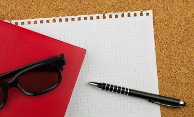 Boş kare beyaz kağıt sayfası metni Not Defteri'nden wrested. Orada gözlük siyah kalın jant, kırmızı defter, siyah kalem ve mantar pano arka plan.