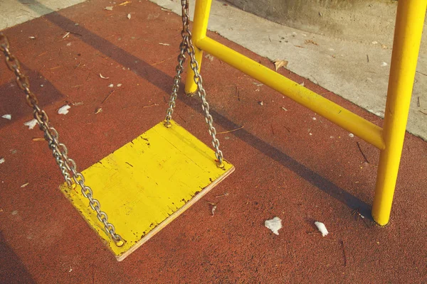 Yellow wooden swing in playground — Stock Photo, Image