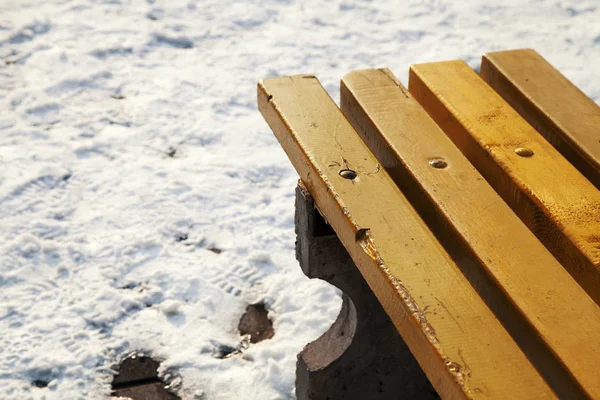 Banco amarelo no parque cercado pela neve — Fotografia de Stock