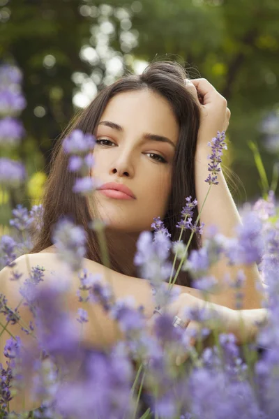 Schöne junge Frau im Blumenfeld — Stockfoto