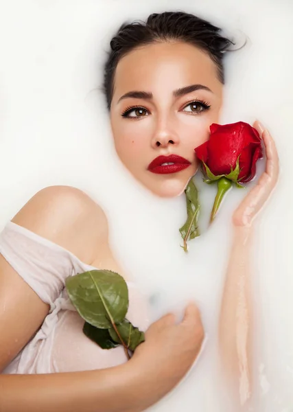Melkachtig bad en rode roos — Stockfoto