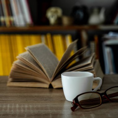 Bir fincan kahve ve kitapla minimalist bir işyeri.