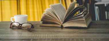 Bir fincan kahve ve kitapla minimalist bir işyeri.