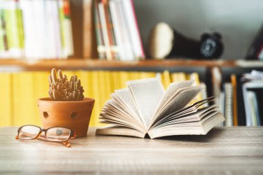 Tenceresinde gözlük ve kaktüs olan minimalist bir işyeri.