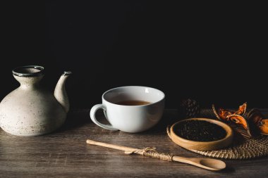 Siyah arkaplanda çaydanlık ve çay fincanları