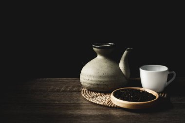 Siyah arkaplanda çaydanlık ve çay fincanları
