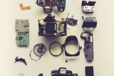 Beyaz arkaplandaki bozuk dijital kameranın üst görünümü, dijital kamera parçaları