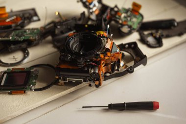 Beyaz arkaplandaki bozuk dijital kameranın üst görünümü, dijital kamera parçaları