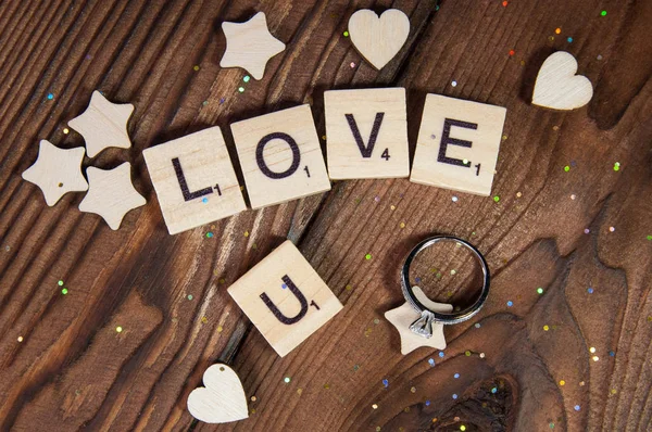 字母表字母木块瓷砖情人节的爱情概念与结婚戒指的木制背景 — 图库照片