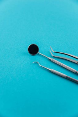 Profesyonel dişçi aletleri seti izole edildi: dişçi aynası, forsepsler kıvrımlı, kaşif. Diş sağlığı ve sağlık hizmetleri konsepti. Dişlerinin arkaplanı. Metin için kopyalama alanı var..