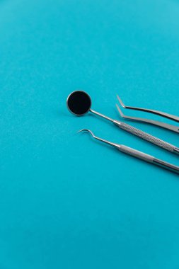 Profesyonel dişçi aletleri seti izole edildi: dişçi aynası, forsepsler kıvrımlı, kaşif. Diş sağlığı ve sağlık hizmetleri konsepti. Dişlerinin arkaplanı. Metin için kopyalama alanı var..