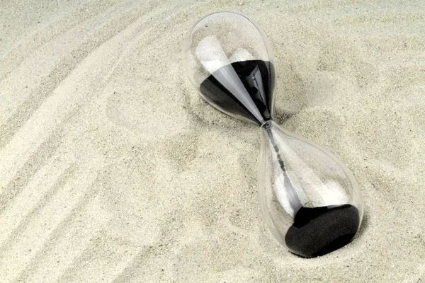 Hourglass on sand background — Stock Photo, Image
