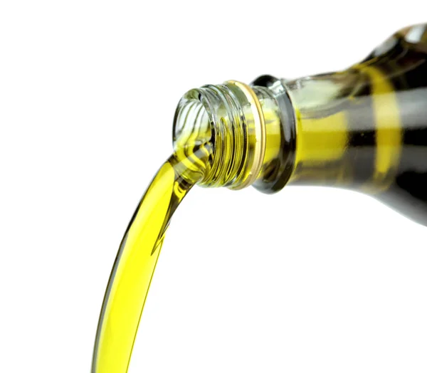 Pouring extra virgin olive oil from glass bottle — Stock Photo, Image