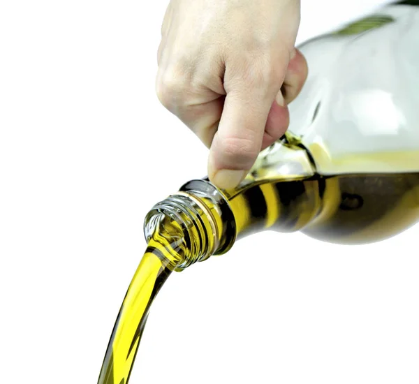 Pouring extra virgin olive oil from glass bottle — Stock Photo, Image