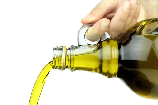 Pouring extra virgin olive oil from glass bottle — Stock Photo, Image