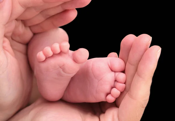 Pied bébé entre les mains de la mère — Photo