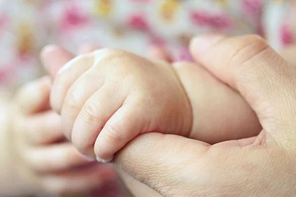 El bebé sostiene el dedo de su madre — Foto de Stock