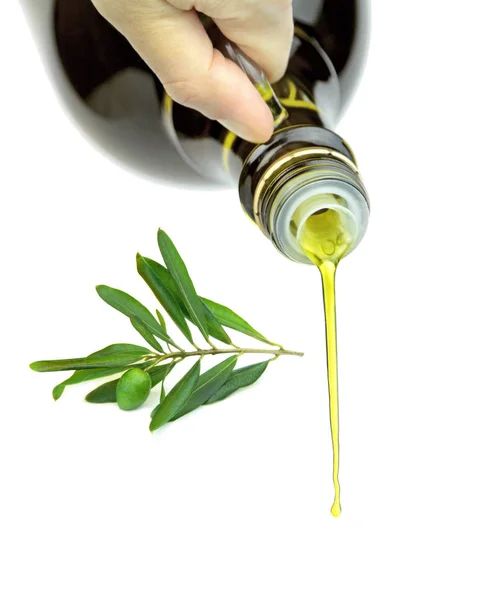 Pouring extra virgin olive oil from glass bottle — Stock Photo, Image