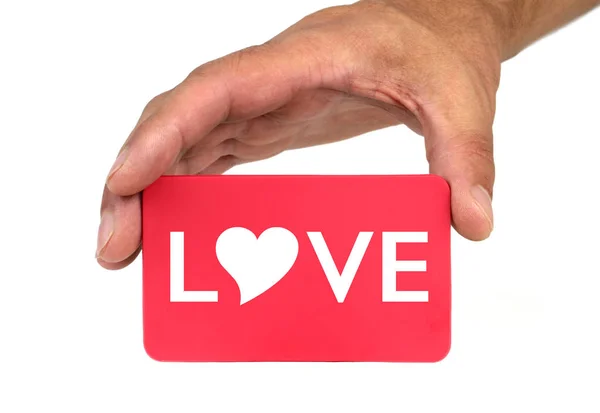 Ręka gospodarstwa i pokazano czerwoną kartkę z kształt tekstu i serce "Miłość". — Zdjęcie stockowe