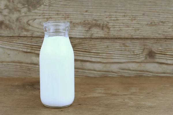 Melk en oude stijl fles op houten tafel — Stockfoto