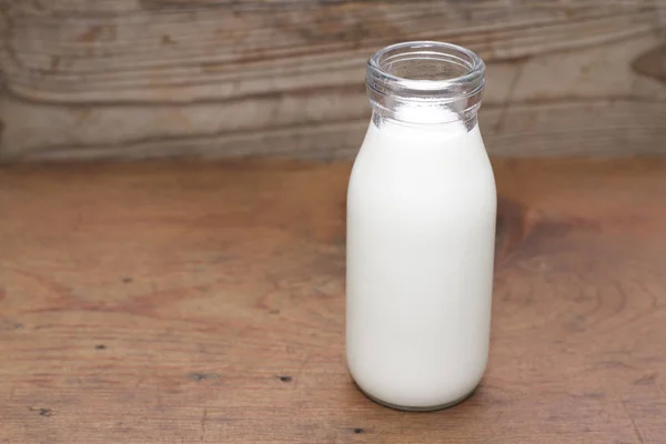 Молоко і пляшка в старому стилі на дерев'яному столі — стокове фото