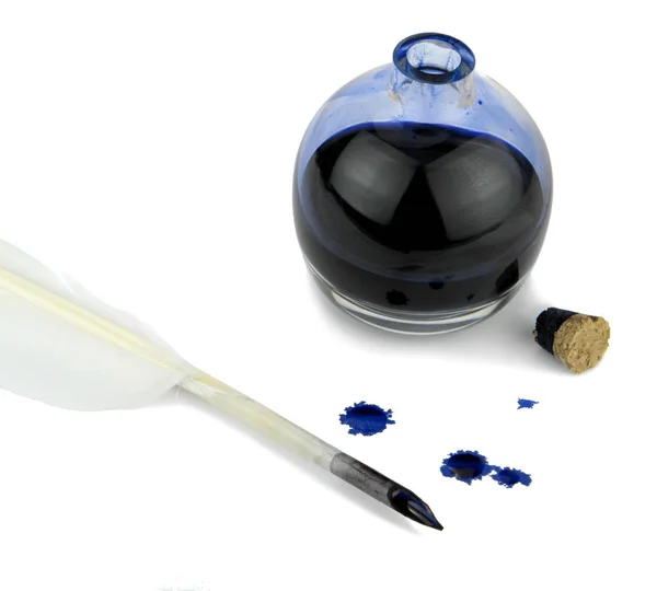 Pluma de pluma con manchas de tinta y botella de tinta de vidrio — Foto de Stock