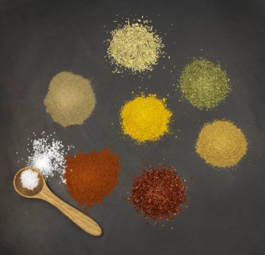 Siyah taş yüzeyinde çeşitli baharatlar