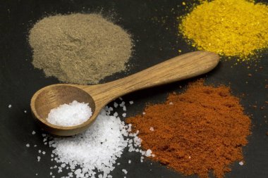 Siyah taş yüzeyinde çeşitli baharatlar