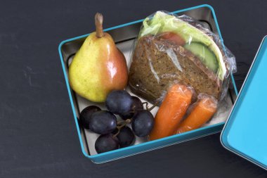 Sağlıklı beslenme çantası, peynirli sandviç, armut, havuç ve üzüm