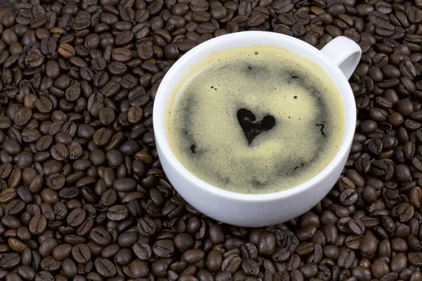 Kaffee mit Herzform auf Kaffeebohnen — Stockfoto